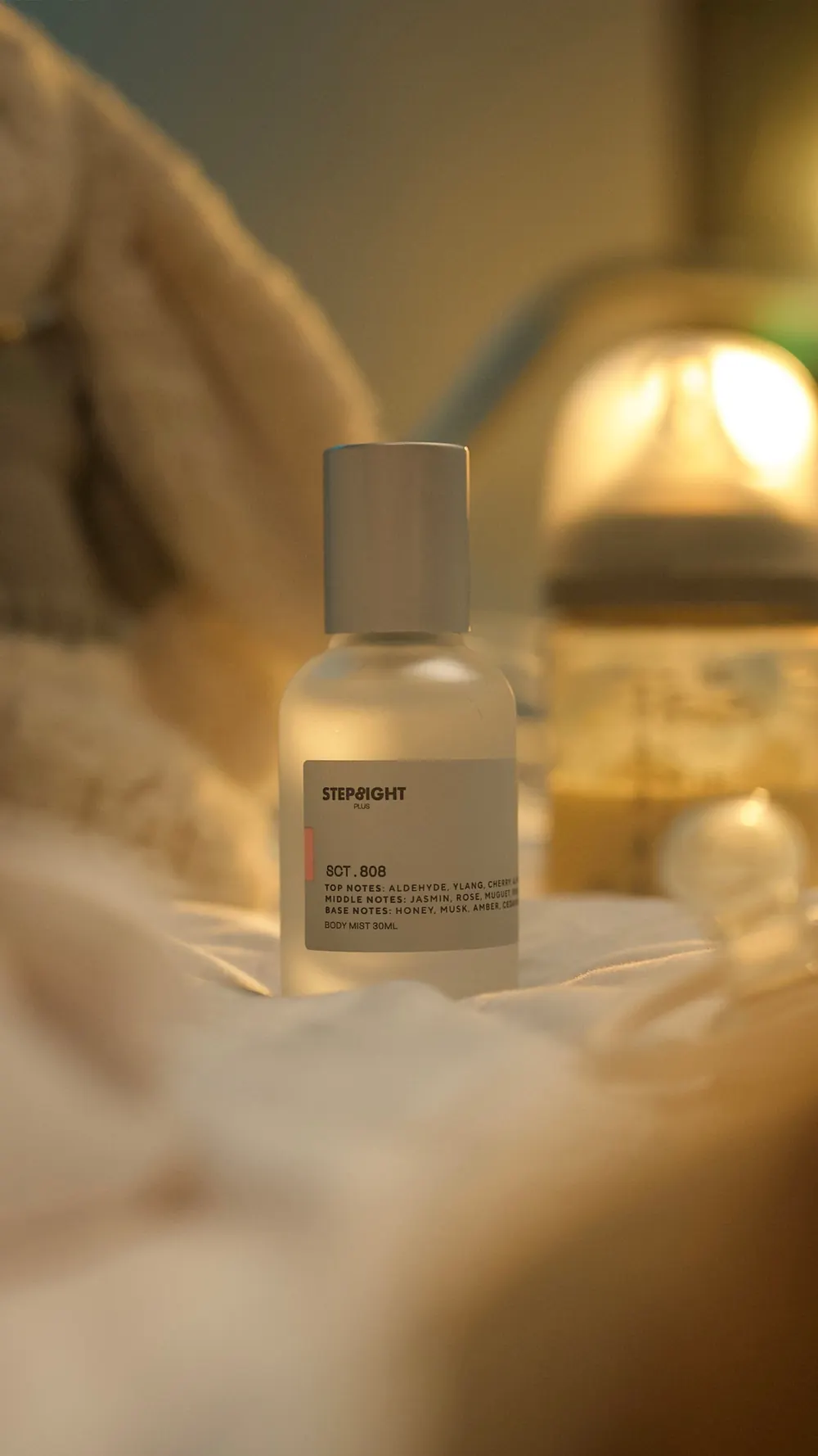 STEP8IGHT Plus body mist bottle glowing beside a lamp